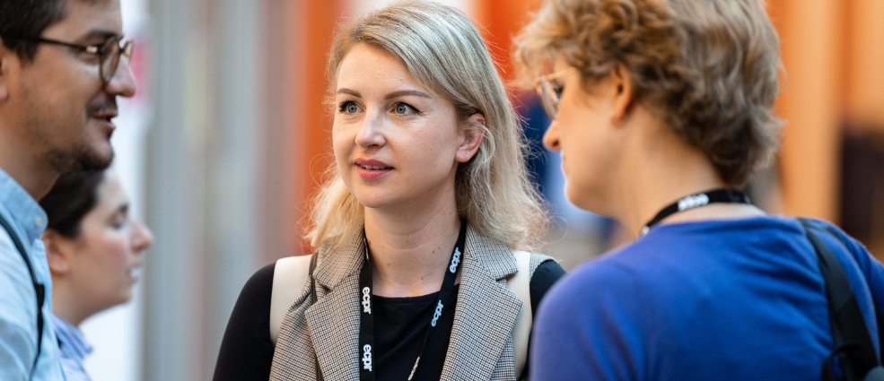 Woman listening intently in a group of people talking at the Regulatory Governance Conference 2023, Antwerp